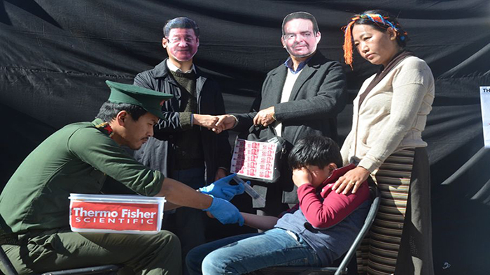 Activists staged a play, showing the CEO of Thermo Fisher and Xi Jinping holding hands and a bag of money in the hand of the CEO. Chinese police using Thermo Fisher kits to collect DNA from Tibetan children. Photo: TPI