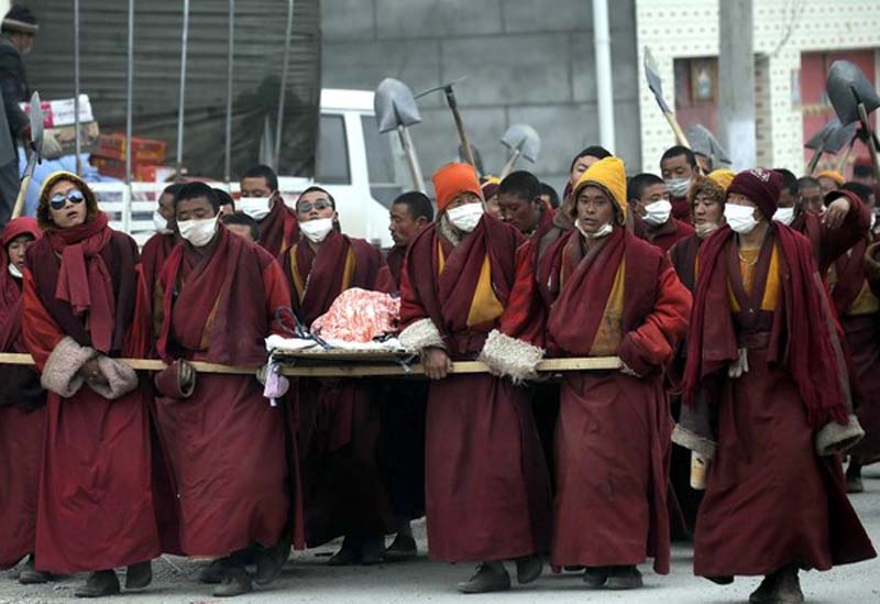 Tibetan monks carry the body of a quake victim during a funeral procession in Kyigudo (Yushu ) county, eastern Tibet, Tso-Ngon Region (Ch: province of Qinghai) on April 21, 2010. Photo: Getty Images