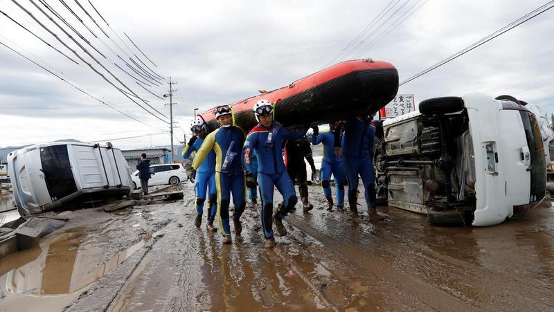 Rescue workers carry a rubber dinghy as they search a flooded area at the Chikuma River in Nagano Prefecture, Japan, October 14, 2019. Reuters