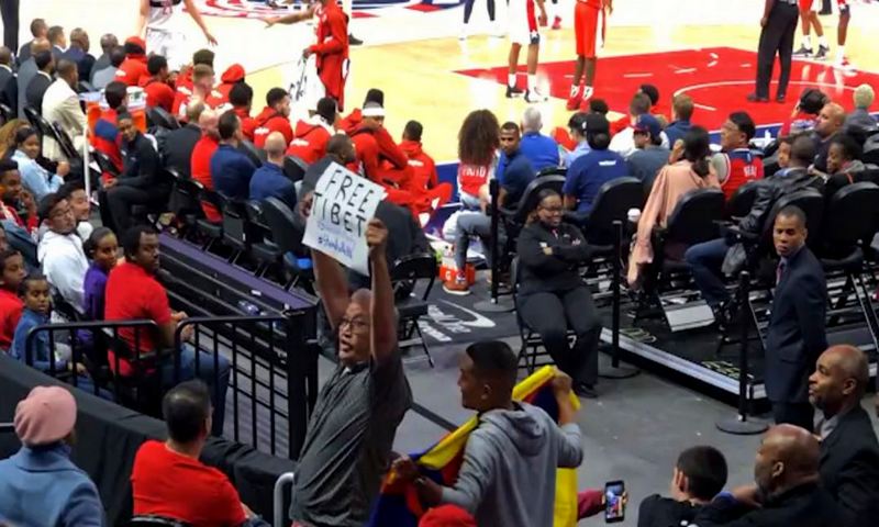 Tenzing Barshee with a placard saying “Free Tibet” and his friend James San Mateo with the Tibetan flag at the NBA game in Washington, D.C. on October 9, 2019. Photo: Youtube Screenshot